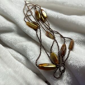 Necklace greenish yellow beads tha are irregular shape, floating between string